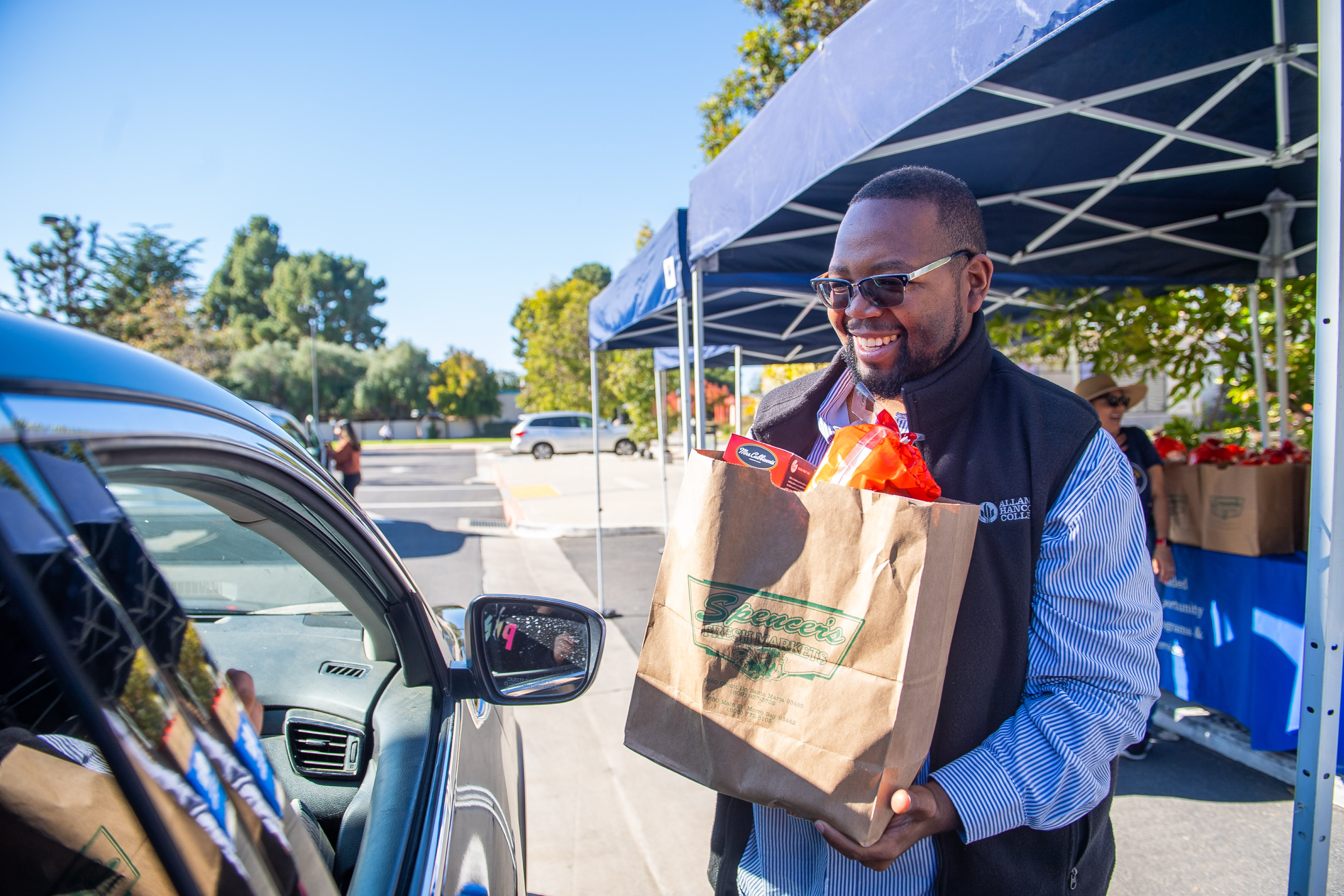 A Hancock staff member gets ready to place a bag of Thanksgiving groceries into a vehicle. 